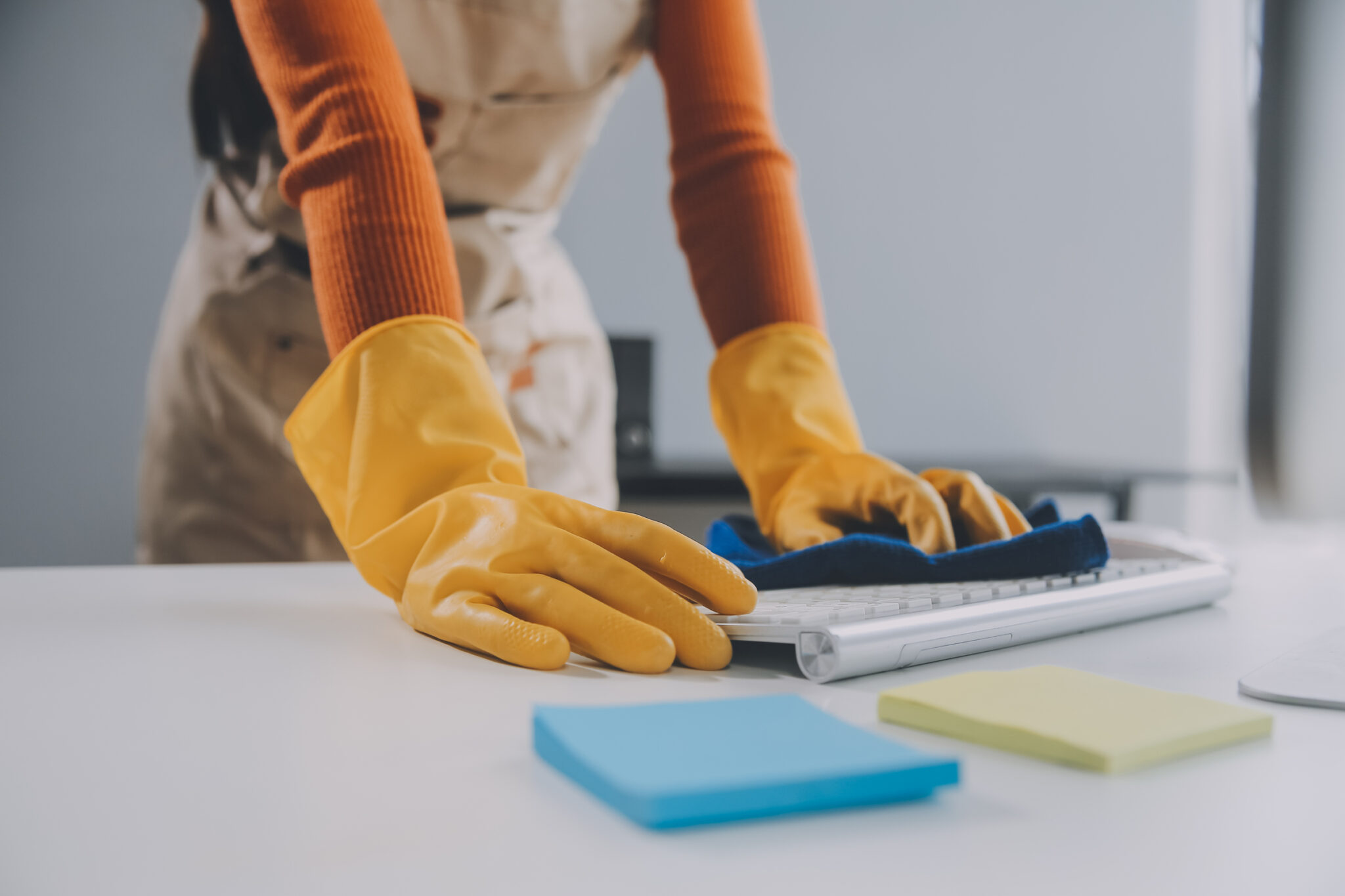 Office Cleaning Service. Janitor Spraying Desk. Workplace Hygiene